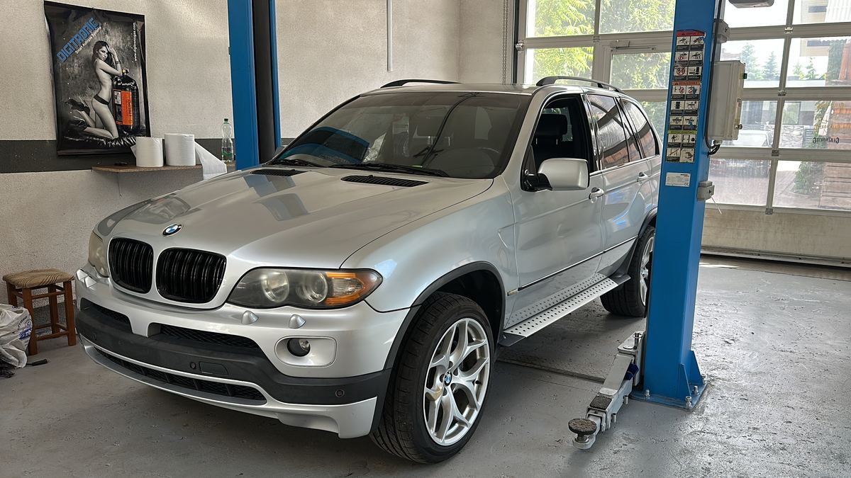 Srebrny SUV na podnośniku w warsztacie Team Motors
